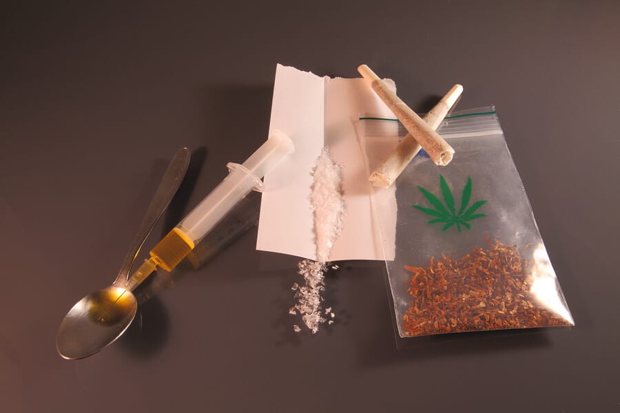 Drug ABC Needle, syringe, white crystals and joint as a symbol for drugs